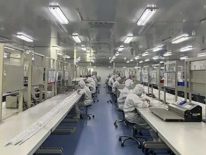 Operators working at cleanroom production workstations