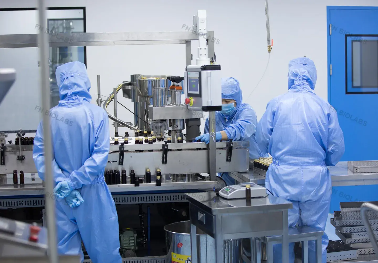 Operators working around a production line in a controlled room