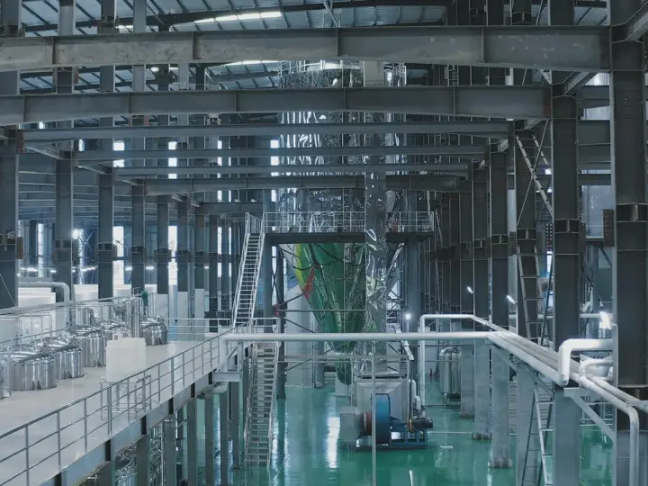 Large industrial processing hall with stainless steel vessels and access platforms